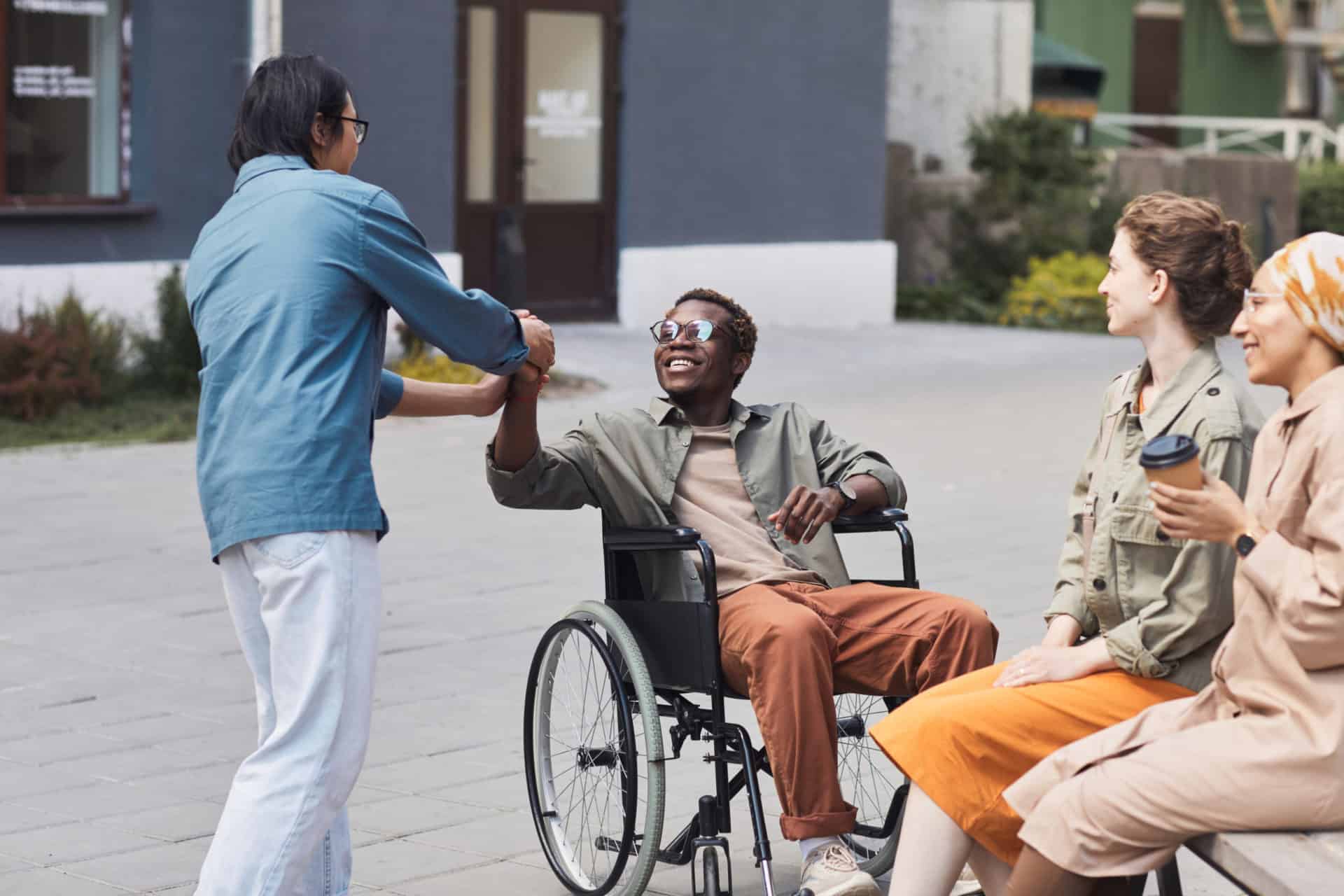 a person smiling in a wheelchair while being with the friends representing NDIS.