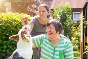 mentally disabled woman with a second woman and a companion dog