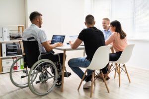 Disabled People In Wheelchair At Workplace Business Meeting